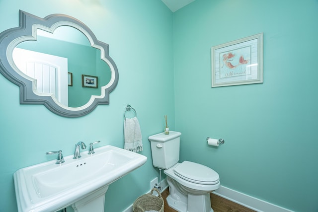 bathroom featuring hardwood / wood-style flooring, toilet, and sink