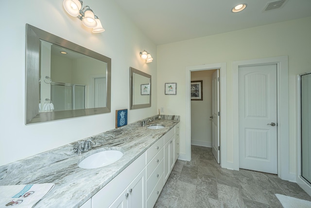 bathroom with vanity and a shower with shower door