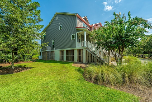 back of house with covered porch and a yard