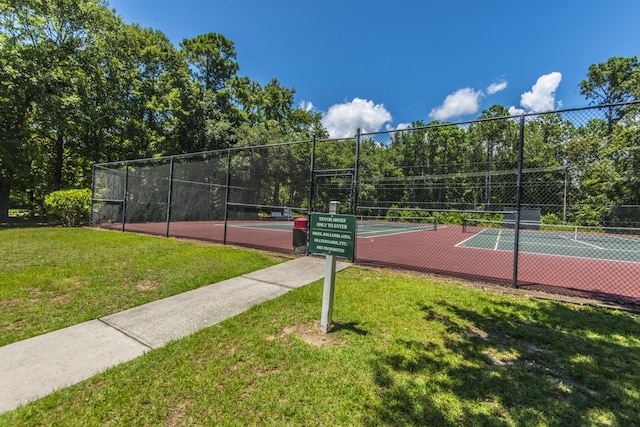 view of sport court with a lawn