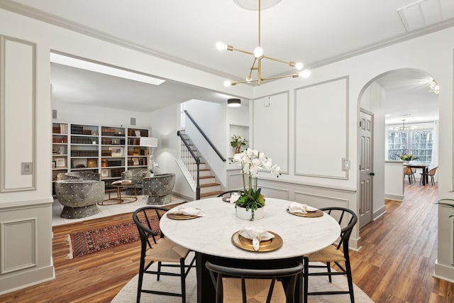 dining space featuring an inviting chandelier, ornamental molding, and dark hardwood / wood-style floors