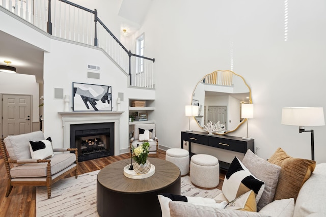 living room with a towering ceiling and light hardwood / wood-style flooring