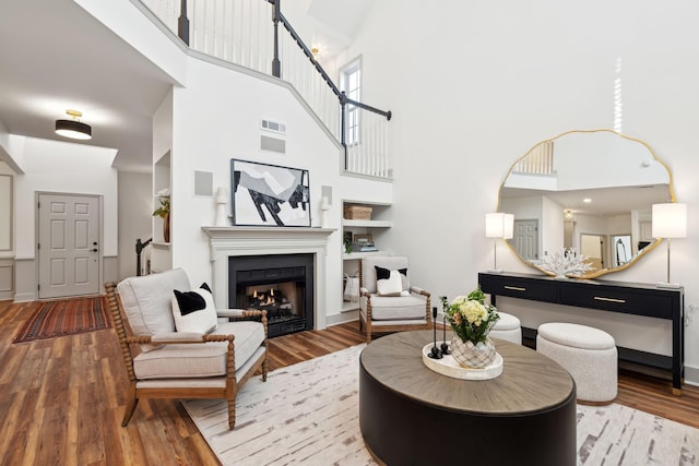 living room with a towering ceiling and light hardwood / wood-style floors