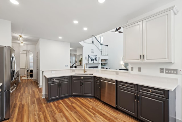 kitchen featuring appliances with stainless steel finishes, sink, white cabinets, and kitchen peninsula