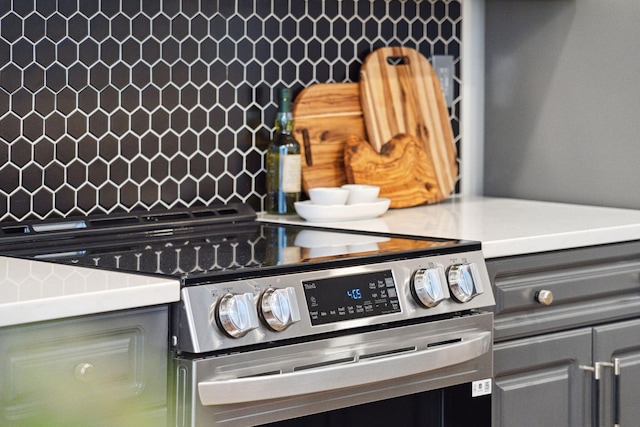 interior details with backsplash and stainless steel electric range oven