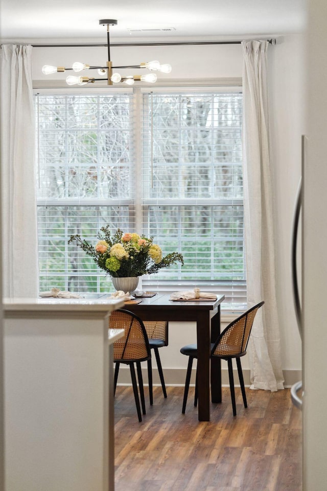 dining area featuring hardwood / wood-style floors and a chandelier