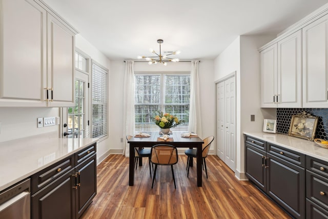 dining area with dark wood-type flooring and a notable chandelier