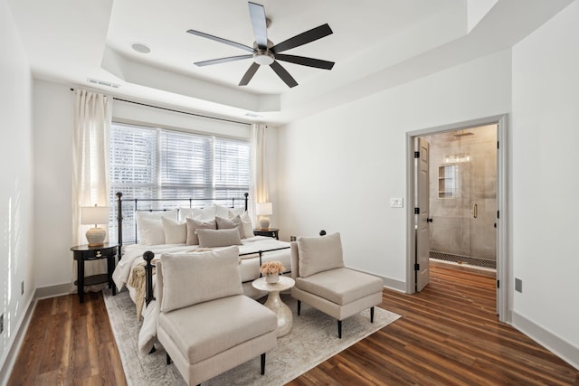 bedroom featuring dark hardwood / wood-style floors, ceiling fan, and a tray ceiling