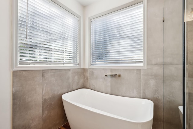 bathroom featuring tile walls and a bathtub