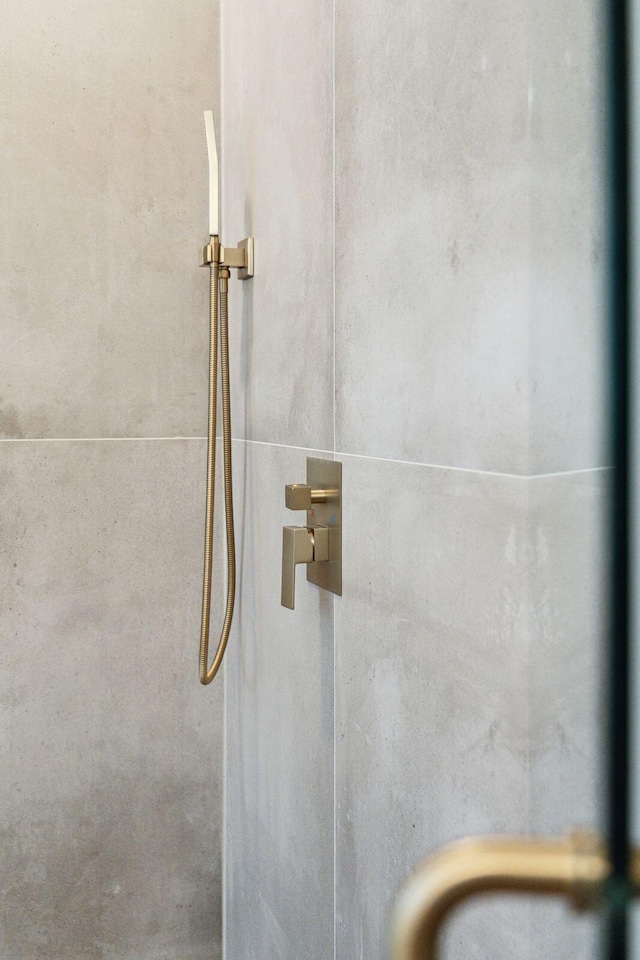 interior details featuring tiled shower