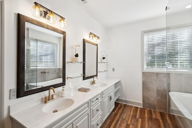 bathroom featuring hardwood / wood-style floors, vanity, and a washtub