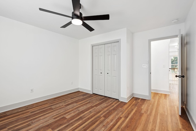 unfurnished bedroom featuring hardwood / wood-style flooring, a closet, and ceiling fan