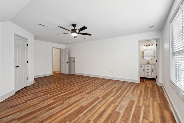 unfurnished bedroom with connected bathroom, light hardwood / wood-style flooring, and ceiling fan