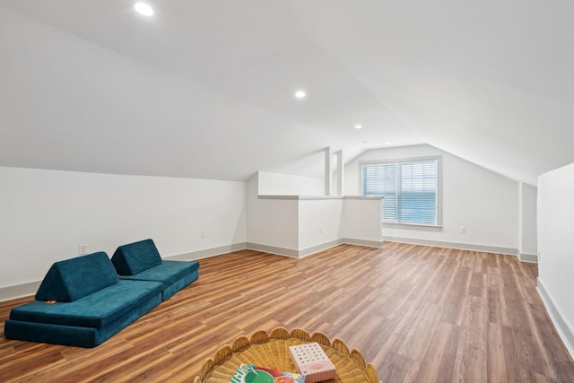 bonus room with lofted ceiling and light wood-type flooring