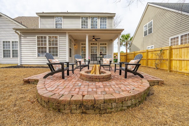 back of house with ceiling fan, a patio area, and a fire pit