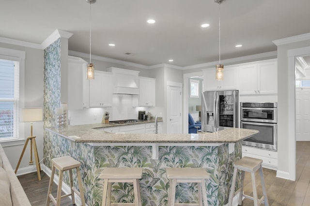 kitchen with wood finished floors, appliances with stainless steel finishes, ornamental molding, light stone countertops, and premium range hood