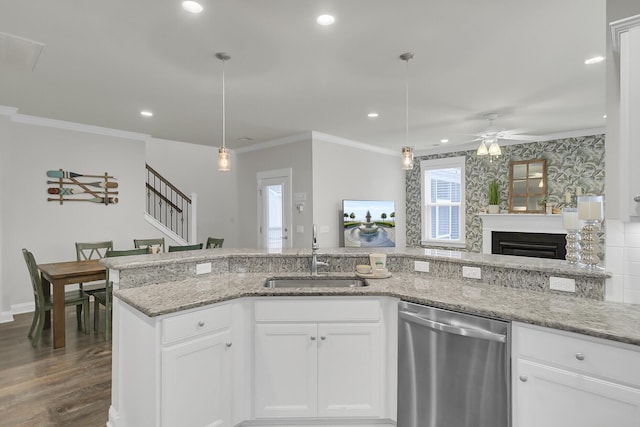 kitchen with dark wood-style floors, recessed lighting, stainless steel dishwasher, ornamental molding, and a sink