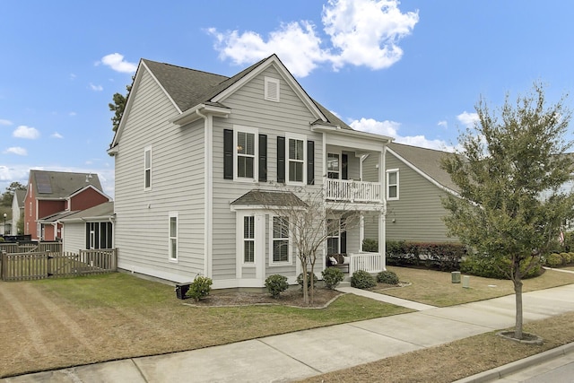 view of front of property with a porch, a front yard, and a balcony