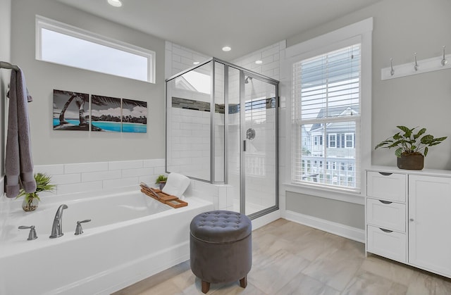 bathroom with a stall shower, plenty of natural light, and a bath