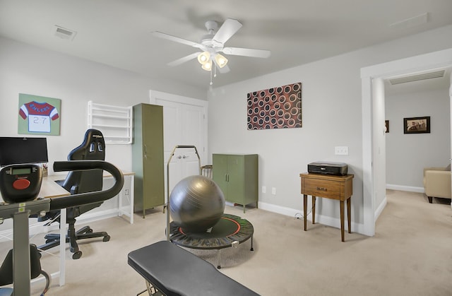 workout area featuring baseboards, visible vents, a ceiling fan, and light colored carpet