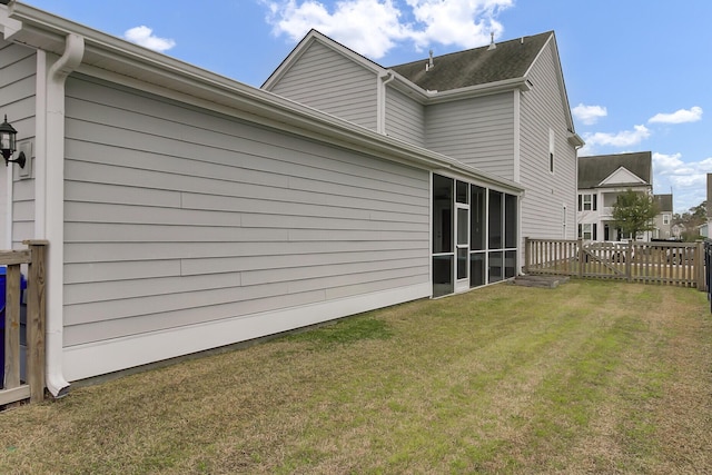 rear view of house with a yard, fence, and a sunroom