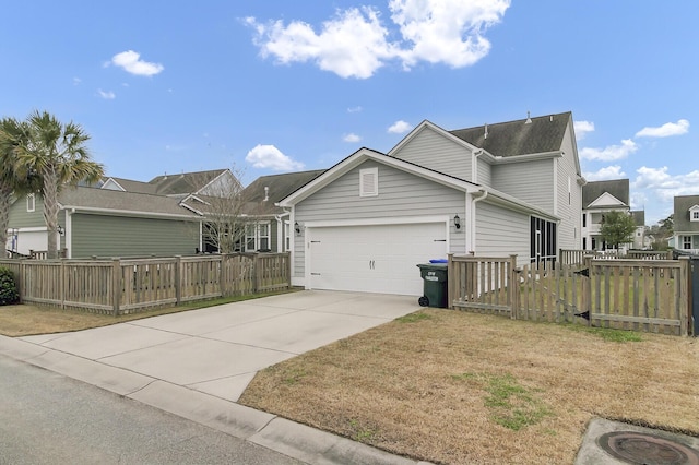 view of front of home with a front lawn, concrete driveway, fence, and an attached garage