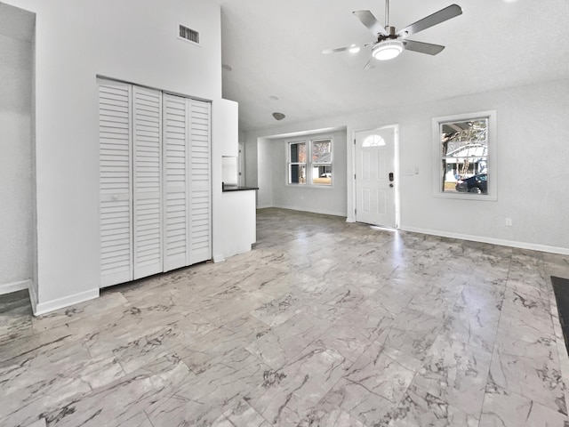 unfurnished living room featuring ceiling fan and lofted ceiling