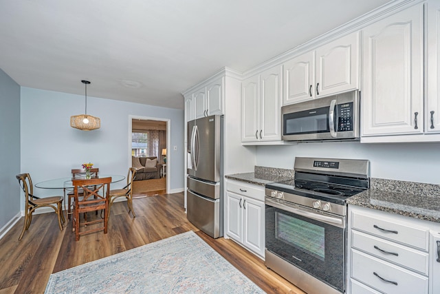 kitchen featuring dark stone counters, stainless steel appliances, dark wood-style flooring, and white cabinetry