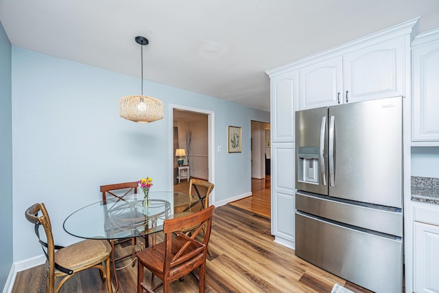 dining room with light wood-style floors and baseboards