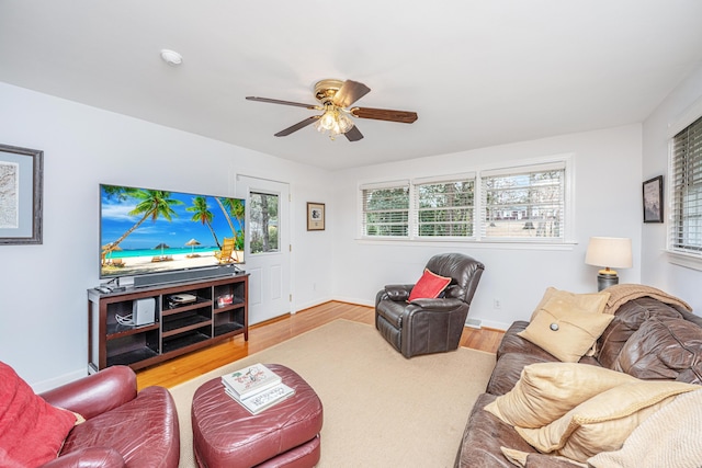 living room with wood finished floors, a ceiling fan, and baseboards