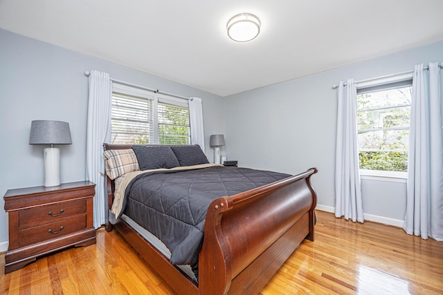 bedroom featuring baseboards and light wood finished floors