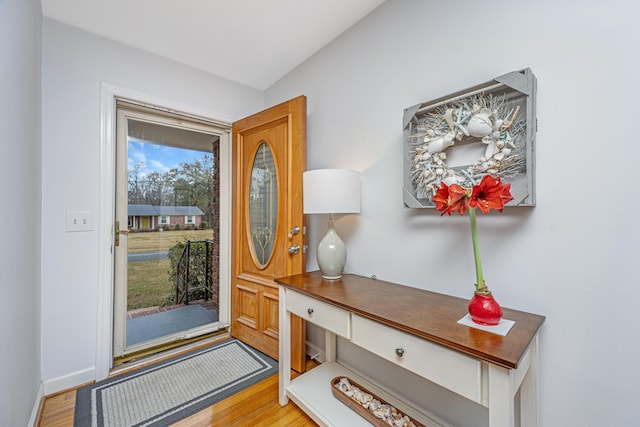 foyer with light wood-type flooring and baseboards