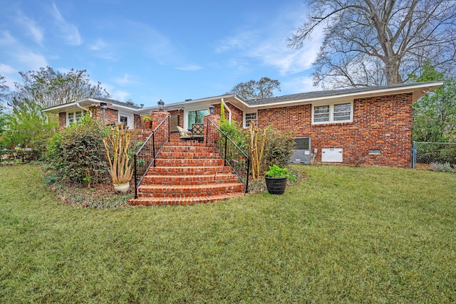 view of front facade with brick siding, crawl space, stairs, fence, and a front yard