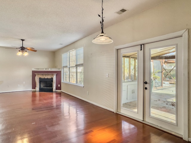 doorway featuring lofted ceiling, dark wood-type flooring, ceiling fan, a premium fireplace, and a textured ceiling