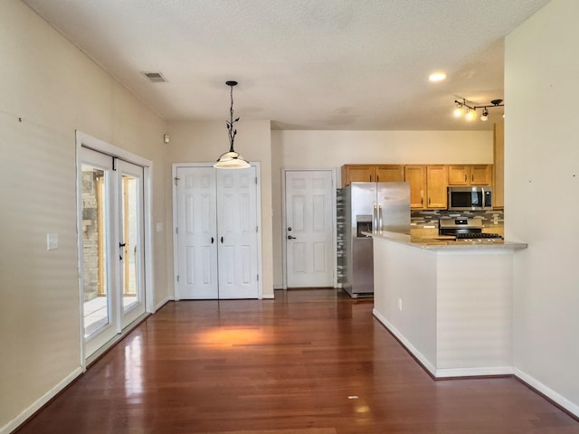 kitchen featuring kitchen peninsula, dark hardwood / wood-style floors, stainless steel appliances, and decorative light fixtures