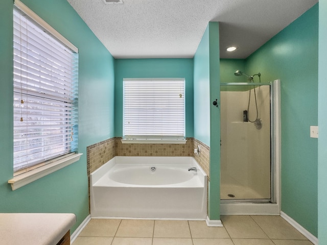 bathroom featuring tile patterned floors, a healthy amount of sunlight, a textured ceiling, and plus walk in shower