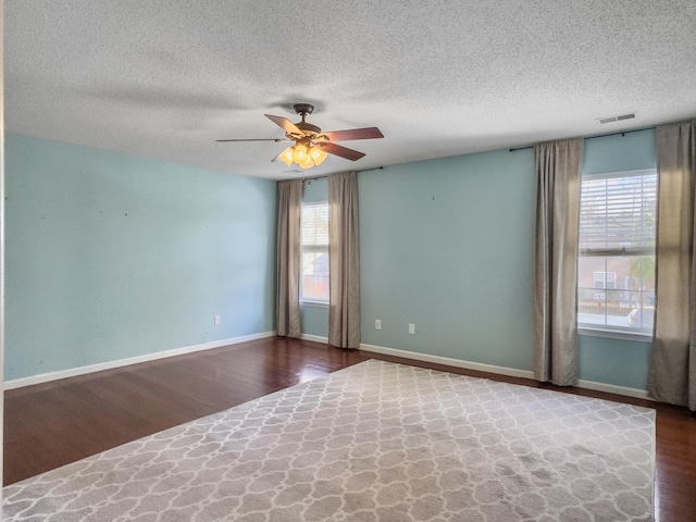 spare room featuring ceiling fan, wood-type flooring, and a textured ceiling