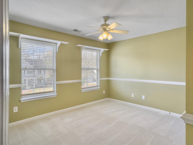 carpeted spare room featuring ceiling fan and a textured ceiling