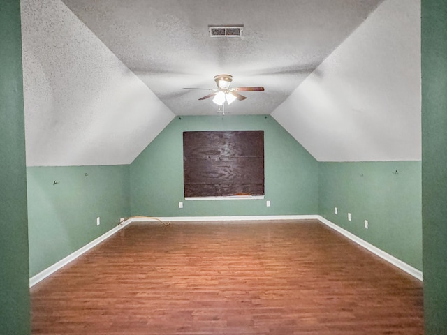 bonus room with lofted ceiling, ceiling fan, hardwood / wood-style floors, and a textured ceiling