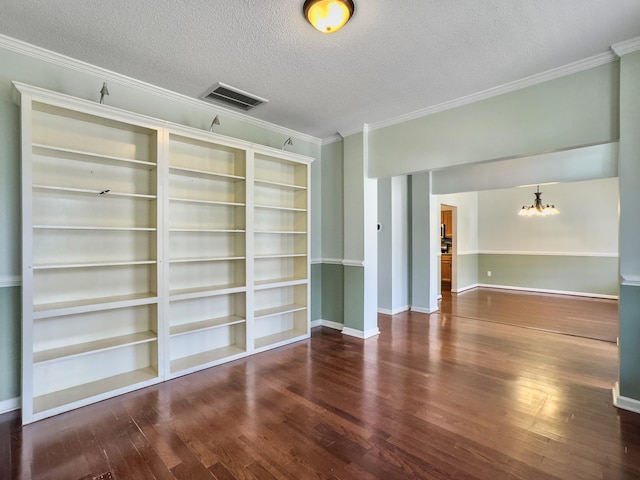 unfurnished living room featuring a textured ceiling, crown molding, built in features, a notable chandelier, and dark hardwood / wood-style floors