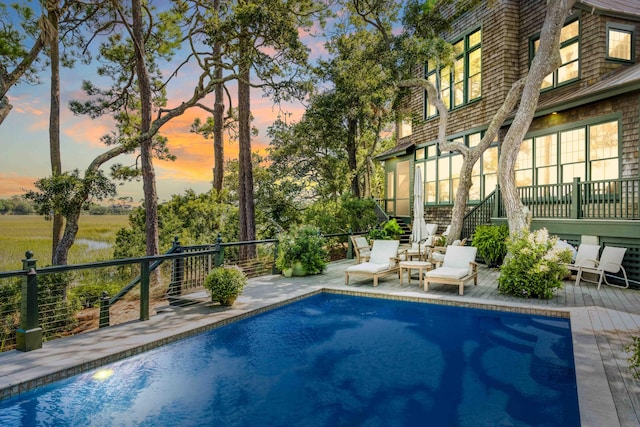 pool at dusk with a wooden deck