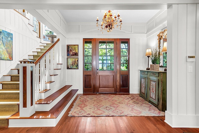 entrance foyer with hardwood / wood-style floors and a chandelier