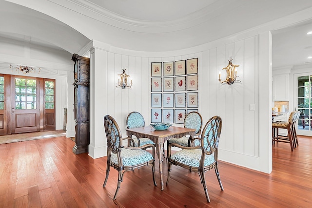 dining space with hardwood / wood-style flooring, ornamental molding, and a healthy amount of sunlight