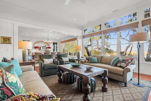 living room featuring crown molding and ceiling fan with notable chandelier