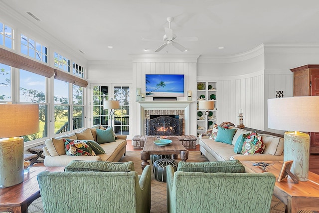 living room with ceiling fan, ornamental molding, a fireplace, and hardwood / wood-style floors