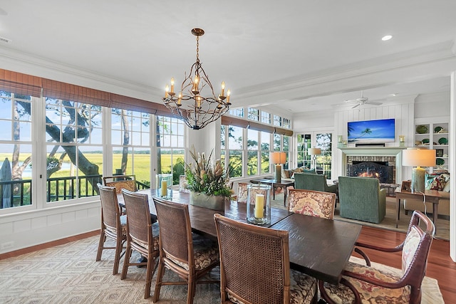 dining room with ornamental molding, a fireplace, and a wealth of natural light