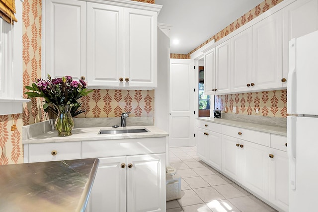 kitchen with sink, white cabinets, stainless steel counters, and white fridge