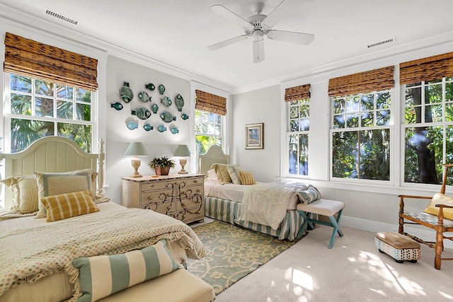 carpeted bedroom with ornamental molding and ceiling fan