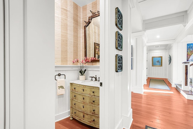 bathroom featuring ornamental molding, vanity, and hardwood / wood-style floors