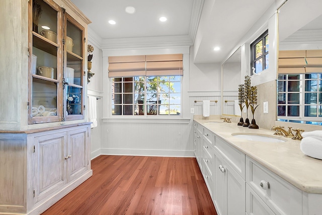 interior space featuring ornamental molding, wood-type flooring, sink, and white cabinets